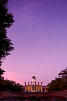 Scenic shot of the University of Missouri sign with the Mizzou Columns and Jesse Hall in the distance at sunrise