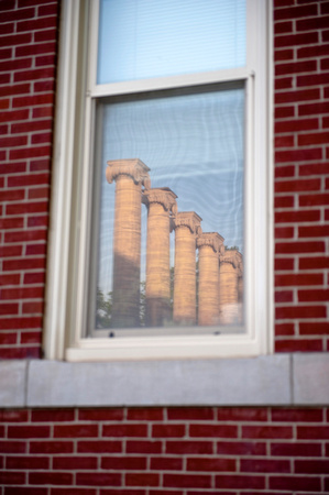 Red bricks surrounding window with 5 columns from mizzou reflecting